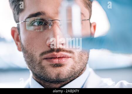 Nahaufnahme der stattlichen bärtigen Immunologe holding Flasche in Klinik Stockfoto