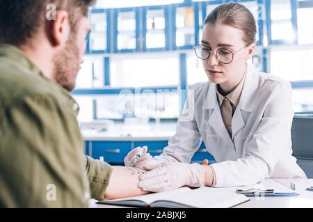 Selektiver Fokus von attraktiven allergist halten Sie die Spritze in der Nähe der Mann in der Klinik Stockfoto