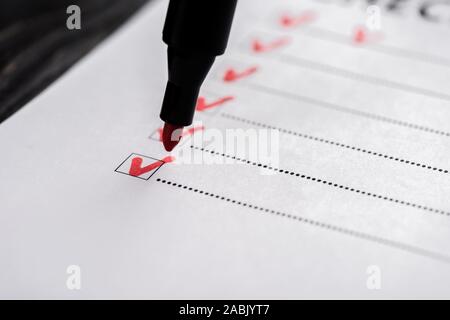 Nahaufnahme der Checkliste mit Zecken in der Nähe von red Marker Pen Stockfoto