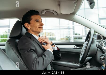 Lächelnd Geschäftsmann Einstellung Binden und Suchen im Spiegel der Drohne Auto Stockfoto