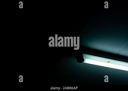 Geöffnet LED Röhre auf dunklem Hintergrund. Leuchtstofflampenlicht geführt. Beleuchtung. Lampe Licht Interieur. Energiesparlampen installiert Stockfoto