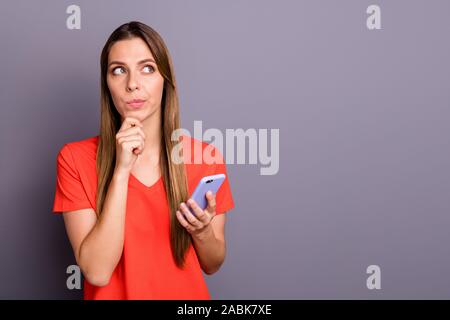 Was text... Portrait von nachdenklich Mädchen benutzen, um Ihr Handy eingeben wollen blogging Post denken Gedanken finger Kinn berühren Sie trendige Kleidung über isoliert Stockfoto