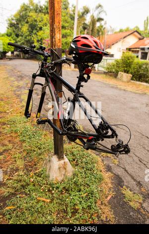 Überreste eines gestohlenen Fahrrads, das an einer Stange auf einer Landstraße befestigt ist. Stockfoto