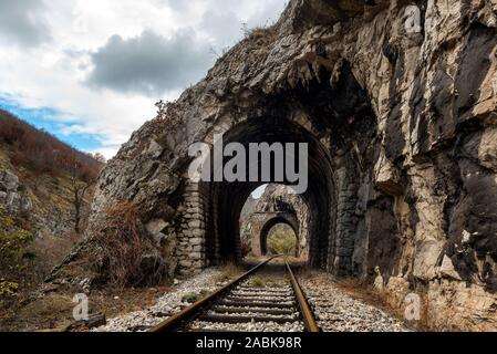 Alten, verlassenen Bahnhof durch kurze Tunnel, die sich in malerischer Landschaft Stockfoto