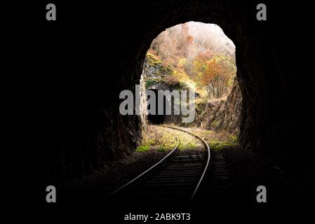 Alten, verlassenen Bahnhof durch kurze Tunnel, die sich in malerischer Landschaft Stockfoto