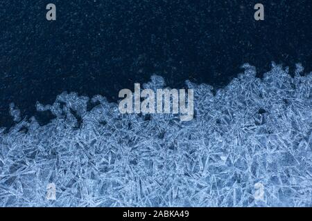 Eis Textur einer halb gefrorenen See Creek mit blauen Kristallen und kalte Farben im Winter Stockfoto
