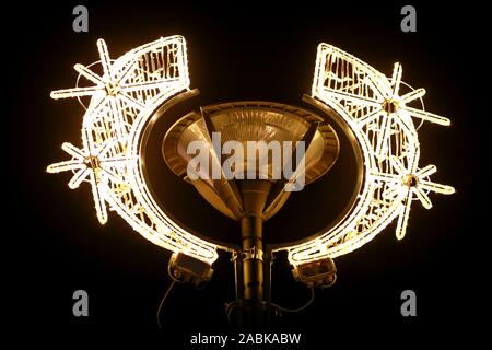 Stadt Silvester und Weihnachten Dekorationen auf Straße Lichtmast, string Reis Glühlampen, hautnah. Dekorative blinkende Lichter, Schmuck zu Weihnachten. Stockfoto