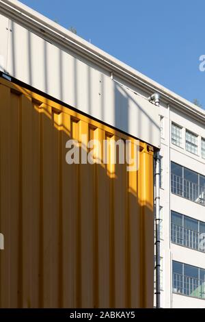 Eindhoven, Niederlande, 4. Mai 2019. Ein Detail von einem gelben Container und im Hintergrund die Olf Philips fabriketagen an einem sonnigen Tag w Stockfoto