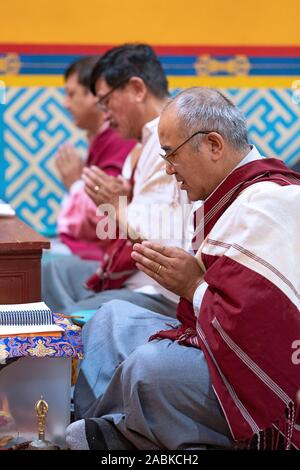 3 frommen buddhistischen Mönche beten und meditieren zu einem monatlichen Throma Puja an einem Tempel in Elmhurst, Queens, New York City. Stockfoto