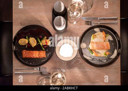 Auf der linken Seite das Gericht "heiß geräuchert Kungsholmen' und 'Frøya 43°' in der Lax-Bar in München. Diese sind ein Stück Lachs direkt über dem Feuer mit rote Beete gekocht, Kartoffeln, mariniert mit Dijon Senf und grünem Spargel und ein warmes Stück Lachs mit einer Kerntemperatur von 43°Celsius. Eine Kartoffel Trüffel Musselin, klassifiziert, Spargel und Möhren mit weißem Trüffel Schaumstoff sind als Beilage serviert. [Automatisierte Übersetzung] Stockfoto