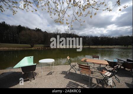 Frühling Atmosphäre im 'Cafe Gans am Wasser' am Ufer des Mollsee im Westpark. Der gesägt Badewanne dient als Sitz. [Automatisierte Übersetzung] Stockfoto