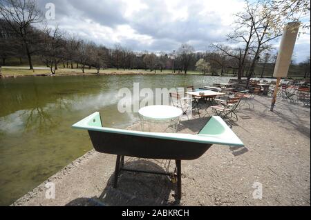 Frühling Atmosphäre im 'Cafe Gans am Wasser' am Ufer des Mollsee im Westpark. Der gesägt Badewanne dient als Sitz. [Automatisierte Übersetzung] Stockfoto