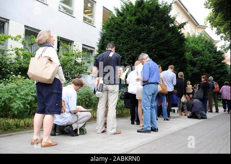 Eine lange Schlange von Gehäuse Asylbewerbern steht morgens um 8.30 Uhr vor dem Büro des Vereins gemeinnützige Wohnungsbaugesellschaft München 1899 verband in der Parzivalstrasse 37 in Schwabing registriert. Das Warten nicht-Mitglieder hoffen, auf der Liste der Interessenten für eine der preiswerten Wohnungen zu beachten. [Automatisierte Übersetzung] Stockfoto