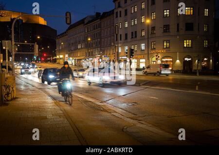 Straßenverkehr auf der Ludwigsbrücke Brücke in der Abenddämmerung. Im Hintergrund der Rosenheimer Berg und dem Gasteig. [Automatisierte Übersetzung] Stockfoto