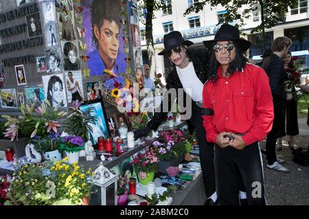 Erinnerungsservice mit zwei Michael Jackson Schauspieler aus dem Musical: Beat it! Vor und im Hotel Bayerischer Hof zum 10. Jahrestag des Todes der US-amerikanischen Pop Star. Im Bild die Doppelten am Denkmal am Promenadeplatz. Nach einer Minute des Schweigens. [Automatisierte Übersetzung] Stockfoto