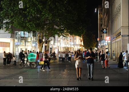 Die Fußgängerzone in der Kaufingerstraße zwischen Marienplatz und Stachus ist voll von Touristen und Spaziergänger an einem warmen Sommerabend. In zwischen Antrieb farbig beleuchteten Rickschas. [Automatisierte Übersetzung] Stockfoto