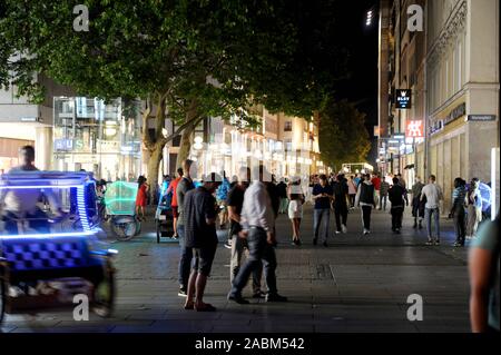 Die Fußgängerzone in der Kaufingerstraße zwischen Marienplatz und Stachus ist voll von Touristen und Spaziergänger an einem warmen Sommerabend. In zwischen Antrieb farbig beleuchteten Rickschas. [Automatisierte Übersetzung] Stockfoto