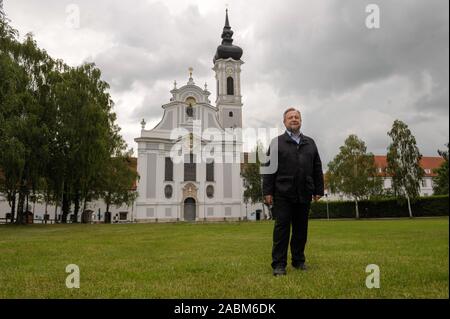 Pastor Josef Kirchensteiner steht vor dem Marienmünster in Dießen am Ammersee. Vor einem Sturm in Sets, der Priester ruft die Mechtildis Bell von der Kathedrale Mariä Himmelfahrt der Jungfrau Maria. [Automatisierte Übersetzung] Stockfoto