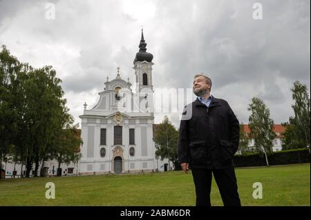 Pastor Josef Kirchensteiner steht vor dem Marienmünster in Dießen am Ammersee. Vor einem Sturm in Sets, der Priester ruft die Mechtildis Bell von der Kathedrale Mariä Himmelfahrt der Jungfrau Maria. [Automatisierte Übersetzung] Stockfoto