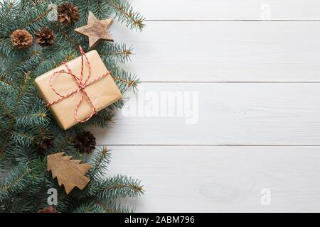 Weihnachten Rahmen von tannenzweigen, Geschenke und Holzspielzeug auf weißem Holzbrett. Ansicht von oben. Platz für Text Stockfoto