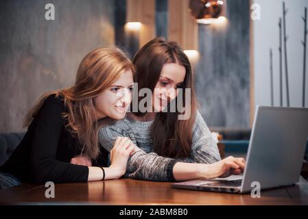 Zwei Mädchen im Netz surfen, auf soziale Netzwerke auf einem Laptop und Spaß haben Stockfoto