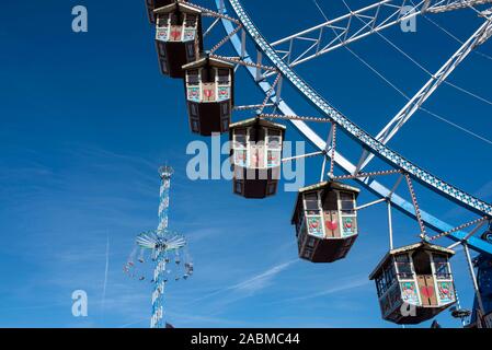 Riesenrad und Karussell Jules Verne Tower (im Hintergrund) auf der Münchner Wiesn. [Automatisierte Übersetzung] Stockfoto