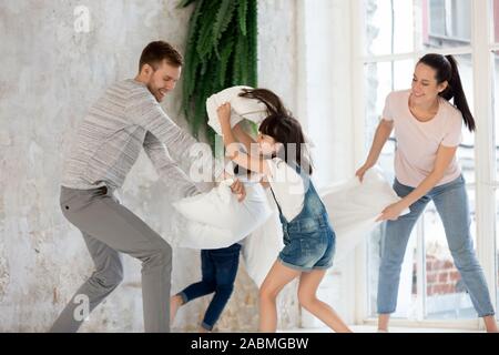 Glückliche junge Familie in der kissenschlacht zu Hause miteinbezogen Stockfoto