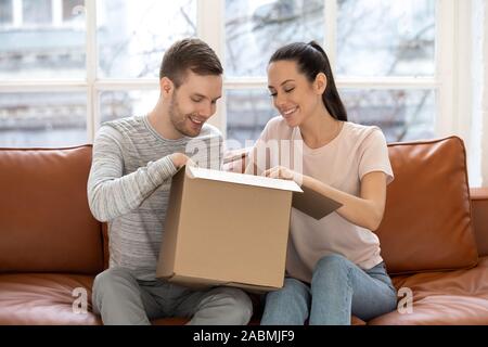 Aufgeregt, junges Paar Paket öffnen online einkaufen Stockfoto