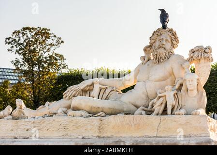 Ein schwarzer Rabe stehend auf die weiße Statue in den Tuilerien in Paris, Frankreich Stockfoto