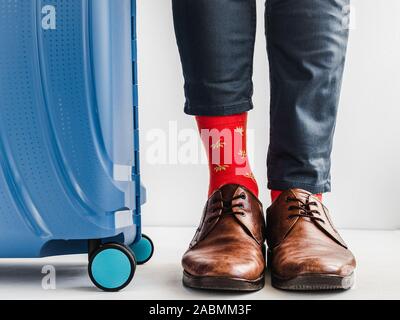 Stilvolle Koffer, Beine der Männer und helle Socken Stockfoto