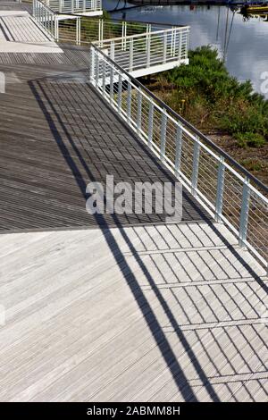Schatten der Balkongeländer auf einem Holzsteg Stockfoto