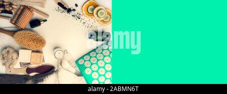 Natürliche und umweltfreundliche Kosmetik für Hautpflege, Ansicht von oben. Serum- und Essenz, Bürsten, Seife, Öl, Massage Tools, Gurke und Orangenscheiben, Kaffee Peeling Stockfoto