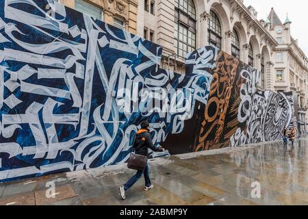 London, Großbritannien. 28. Nov 2019. London, Großbritannien. 28. Nov 2019. Embargoland Online bis 0001 29/11/19 OK für Drucken Morgen - Japanische Modelabel Comme des Garcons in Zusammenarbeit mit Opera Gallery in London stellt eine große Graffiti Wandgemälde auf der Vorderseite des Gebäudes Dover Street Market. Es wurde von der Russischen Kalligraphie und Graffiti Künstler Pokras Lampas erstellt, im Rahmen der Feierlichkeiten zum 15. Jahrestag der Dover Street Market. Credit: Guy Bell/Alamy leben Nachrichten Stockfoto