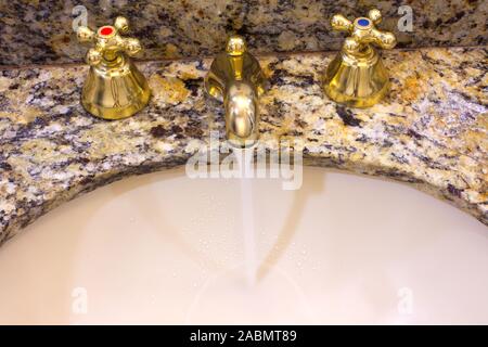 Wasserhahn in einem Hotel Badezimmer mit fließendem Wasser Stockfoto