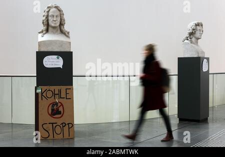 Leipzig, Deutschland. 28 Nov, 2019. Ein Karton Zeichen' Kohle Stopp' steht an der Unterseite der Büste von Gottfried Wilhelm Leibniz während der Climate Action Woche im neuen Augusteum der Universität Leipzig. Mit Mahnwachen, Menschenketten und Blockaden, Klima Aktivisten wollen für einen sofortigen Abzug aus Braunkohle in der Leipziger Kohle Bezirk am Wochenende zu protestieren. Die Veranstalter erwarten mehrere hundert Demonstranten in der Gegend um Leipzig und in der Lausitz. Kredite: Jan Woitas/dpa-Zentralbild/dpa/Alamy leben Nachrichten Stockfoto