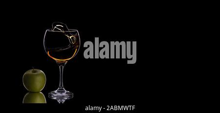 In der Nähe von Glas mit Whiskey mit grünem Apfel auf einem dunklen Hintergrund mit kopieren. Dark-Modus. Essen Foto für Banner. Die Schwerelosigkeit. Konzept, Vertrieb, d Stockfoto