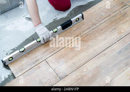 Reparatur und Dekoration. Die fliesenleger setzt das Porzellan Fliesen auf dem Fußboden in der Wohnung Stockfoto