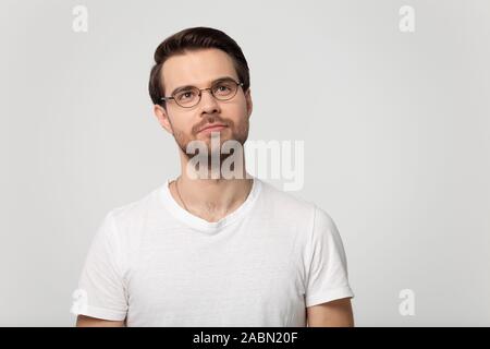 Nachdenklicher Mann in Gläser look up erwägt Verkauf Angebot Stockfoto