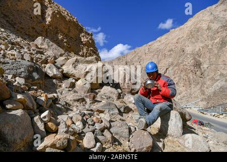 (191128) -- TAXKORGAN, November 28, 2019 (Xinhua) - Wang Siming, ein Techniker aus dem Südwesten Chinas Provinz Yunnan, Mittagessen an der Baustelle des Stromnetzes im Bau Maryang Township, Tadschikische Autonome Kreis Taxkorgan, Nordwesten Chinas Autonome Region Xinjiang Uygur, Nov. 23, 2019. Maryang Township und Datong Gemeinde sind im Pamir Plateau inmitten von hohen Bergen und tiefen Tälern, weit entfernt von der Kreisstadt entfernt. Für eine lange Zeit, das Gelände wird die langsame Entwicklung der Macht und andere Infrastruktur, die das größte Hindernis für die lokale Armut alleviati werden Stockfoto