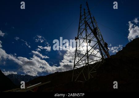 (191128) -- TAXKORGAN, November 28, 2019 (Xinhua) - Techniker arbeiten an einer elektrischen Sendemast in Maryang Township, Tadschikische Autonome Kreis Taxkorgan, Nordwesten Chinas Autonome Region Xinjiang Uygur, Nov. 23, 2019. Maryang Township und Datong Gemeinde sind im Pamir Plateau inmitten von hohen Bergen und tiefen Tälern, weit entfernt von der Kreisstadt entfernt. Für eine lange Zeit, das Gelände wird die langsame Entwicklung der Macht und andere Infrastruktur, die das größte Hindernis für die lokale Bekämpfung der Armut geworden. Auch die Photovoltaik Power Panels, die von der Regierung kann nur erfüllen Stockfoto