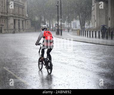 London, England, UK. Radfahrer in strömendem Regen Stockfoto