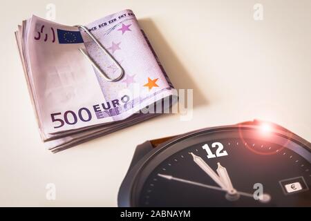 Armbanduhr mit einem Bündel von Fünfhundert Euro-Banknoten Stockfoto