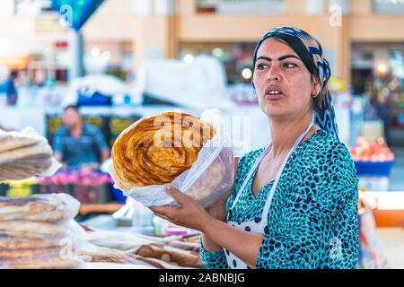 SAMARKAND, Usbekistan - Mai 10, 2019: Frau Verkauf von Brot an siab Basar im Zentrum von Samarkand, Usbekistan Stockfoto