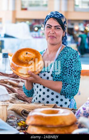SAMARKAND, Usbekistan - Mai 10, 2019: Frau Verkauf von Brot an siab Basar im Zentrum von Samarkand, Usbekistan Stockfoto