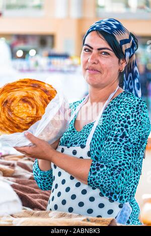 SAMARKAND, Usbekistan - Mai 10, 2019: Frau Verkauf von Brot an siab Basar im Zentrum von Samarkand, Usbekistan Stockfoto