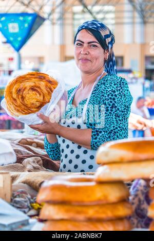 SAMARKAND, Usbekistan - Mai 10, 2019: Frau Verkauf von Brot an siab Basar im Zentrum von Samarkand, Usbekistan Stockfoto