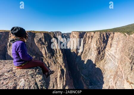 Schöne Frau macht Handstand an der schwarzen Schlucht des Gunnison Stockfoto