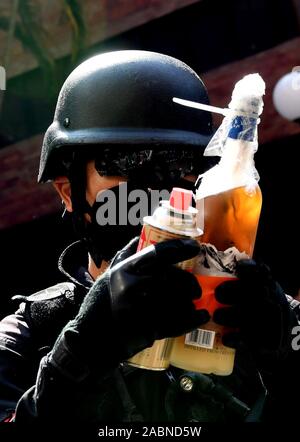 Hong Kong. 28 Nov, 2019. Ein Polizist Griffe gefährliche Gegenstände auf dem Campus der Hong Kong Polytechnic University (PolyU) Hong Kong, South China, Nov. 28, 2019. Gehen mit 'Feature: Hong Kong Polizei, Feuerwehr ein PolyU zur Untersuchung "Credit: Zhu Xiang/Xinhua/Alamy leben Nachrichten Stockfoto