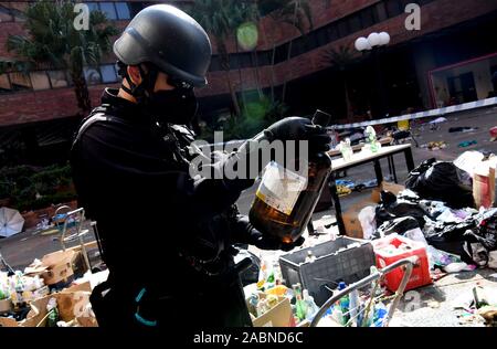 Hong Kong. 28 Nov, 2019. Ein Polizist Griffe gefährliche Gegenstände auf dem Campus der Hong Kong Polytechnic University (PolyU) Hong Kong, South China, Nov. 28, 2019. Gehen mit 'Feature: Hong Kong Polizei, Feuerwehr ein PolyU zur Untersuchung "Credit: Zhu Xiang/Xinhua/Alamy leben Nachrichten Stockfoto
