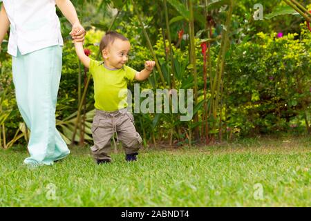 Happy Toddler Boy Laufen lernen im Gras Stockfoto